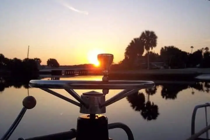 Sunrise over the water from the wheel of the boat